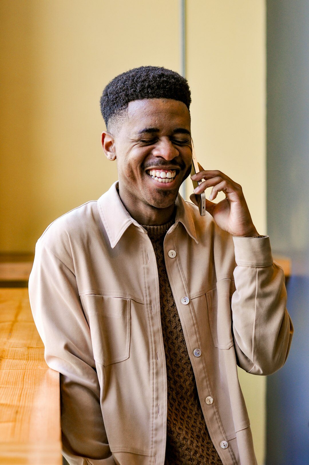 Afro-Brazilian man smiling while talking on the phone